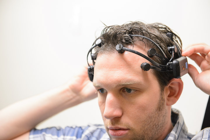 ASU educational technology doctoral student John Sadauskas demonstrates use of an EEG headset, one of three kinds of sensors helping researchers observe student behavior and physiological responses while using Facebook. The research project at the Learning Sciences Institute’s Advancing Next Generation Learning Environments (ANGLE) Lab at ASU is overseen by Associate Professor Robert Atkinson.